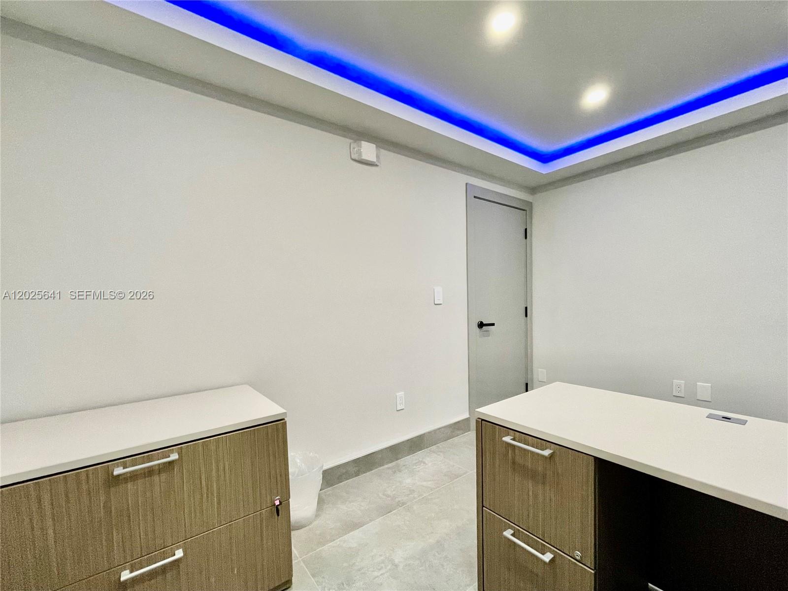 An office room features light-colored tile floors, wood-grain cabinets, and blue recessed ceiling lighting — 6280 W Atlantic Blvd, Margate FL 33063, MARGATE, FL