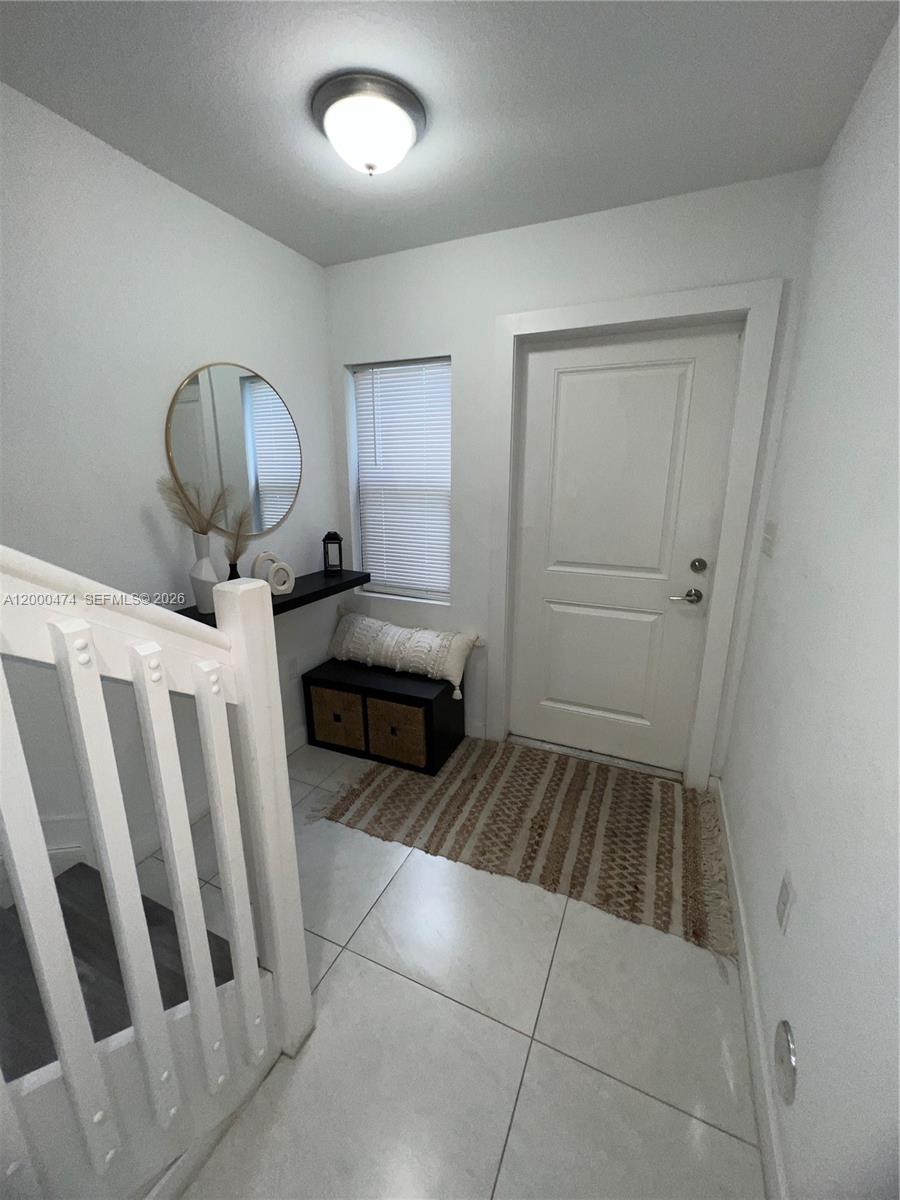 A bright entryway features white walls, tiled floors, a staircase, and a small storage bench — 2954 NW 57th St # 2954, Miami FL 33142, MIAMI, FL