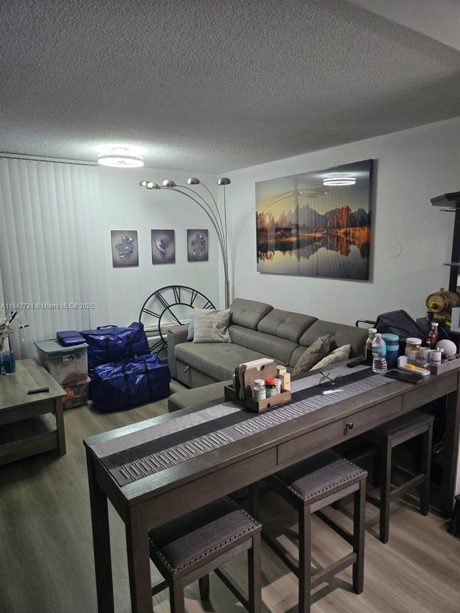 A living room features a grey sofa, a tall console table, and a large landscape print — 16450 NW 2nd Ave # 310, Miami FL 33169, MIAMI, FL