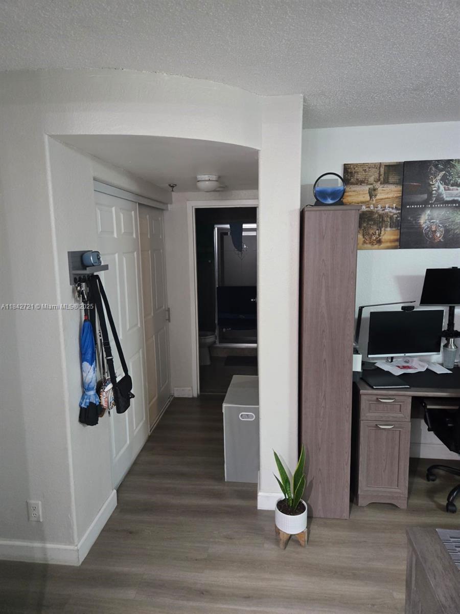 A hallway leads to a bathroom, with a desk area and closet visible nearby — 16450 NW 2nd Ave # 310, Miami FL 33169, MIAMI, FL