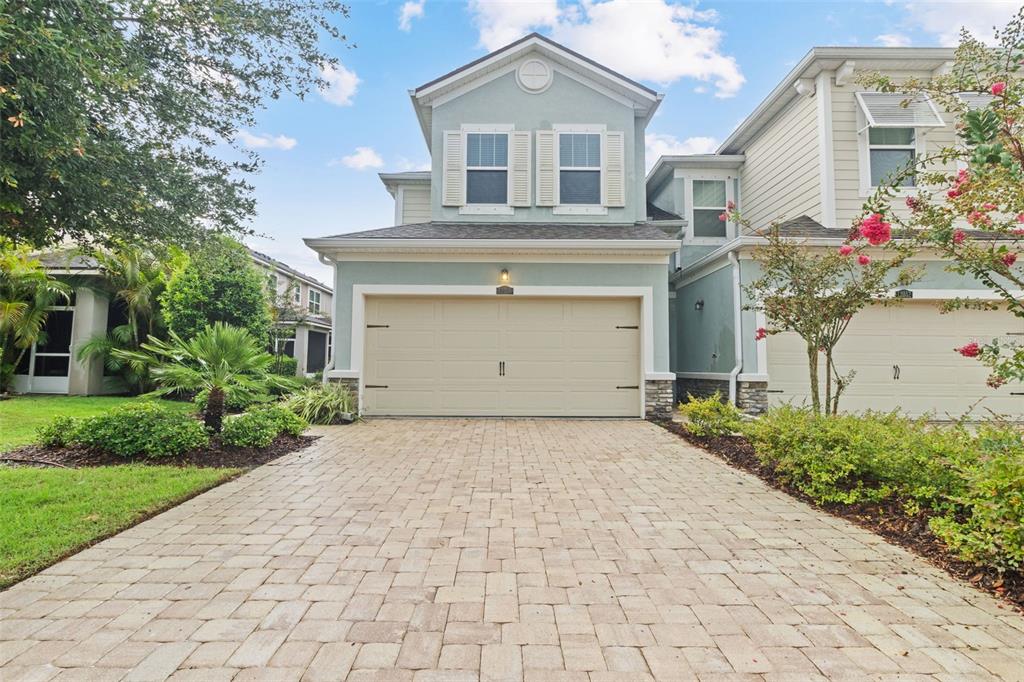 A two-story light blue house with a beige garage door and a paved driveway — 12356 TRAILHEAD DRIVE, BRADENTON, FL