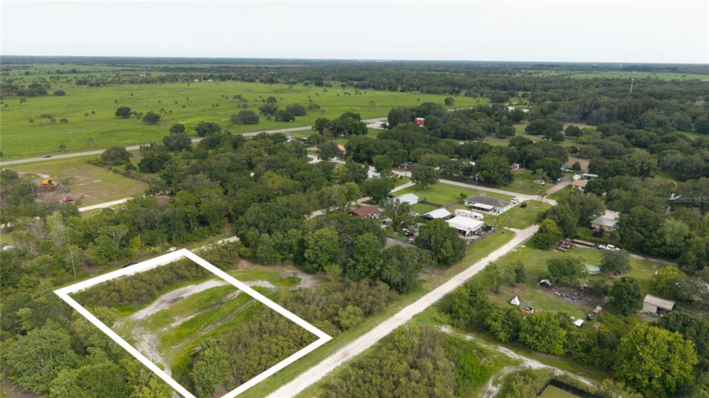 An aerial view shows a rectangular plot of land outlined in white near a road — NE 2ND TERRACE, OKEECHOBEE, FL