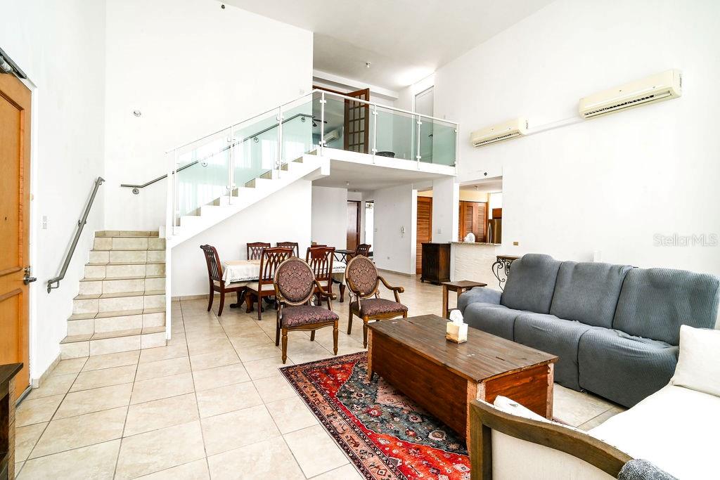 A living room with tile floors, a staircase, a dining area, and a loft balcony — 9 PALACIOS DEL ESCORIAL UNIT 9-71, CAROLINA, PR