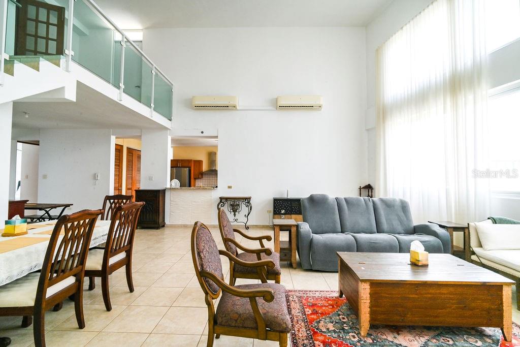 A spacious living and dining area features high ceilings, tile floors, and a loft balcony — 9 PALACIOS DEL ESCORIAL UNIT 9-71, CAROLINA, PR