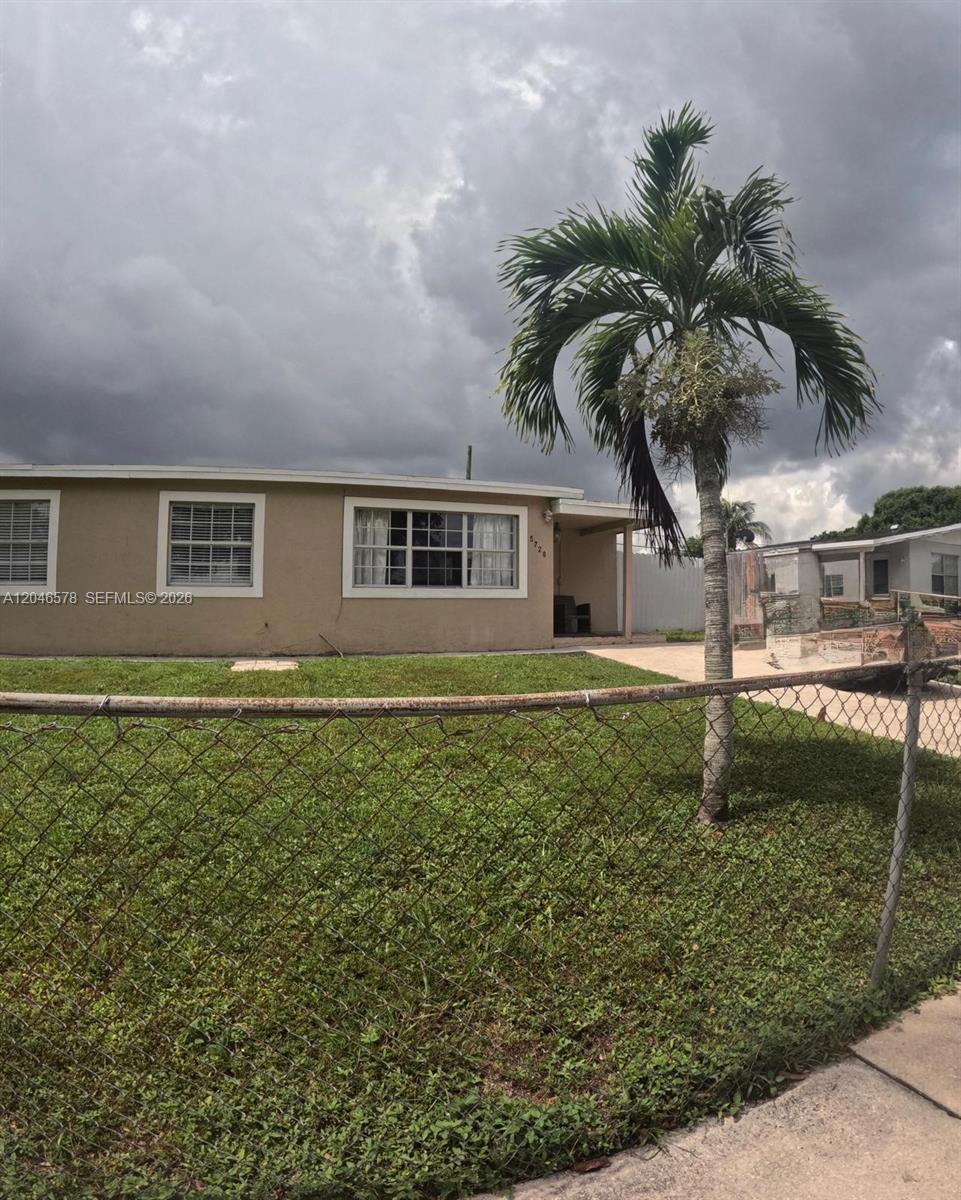 A single-story house with a tan exterior, a palm tree, and a chain-link fence — 5720 SW 38th Ct # 5720, Davie FL 33314, DAVIE, FL