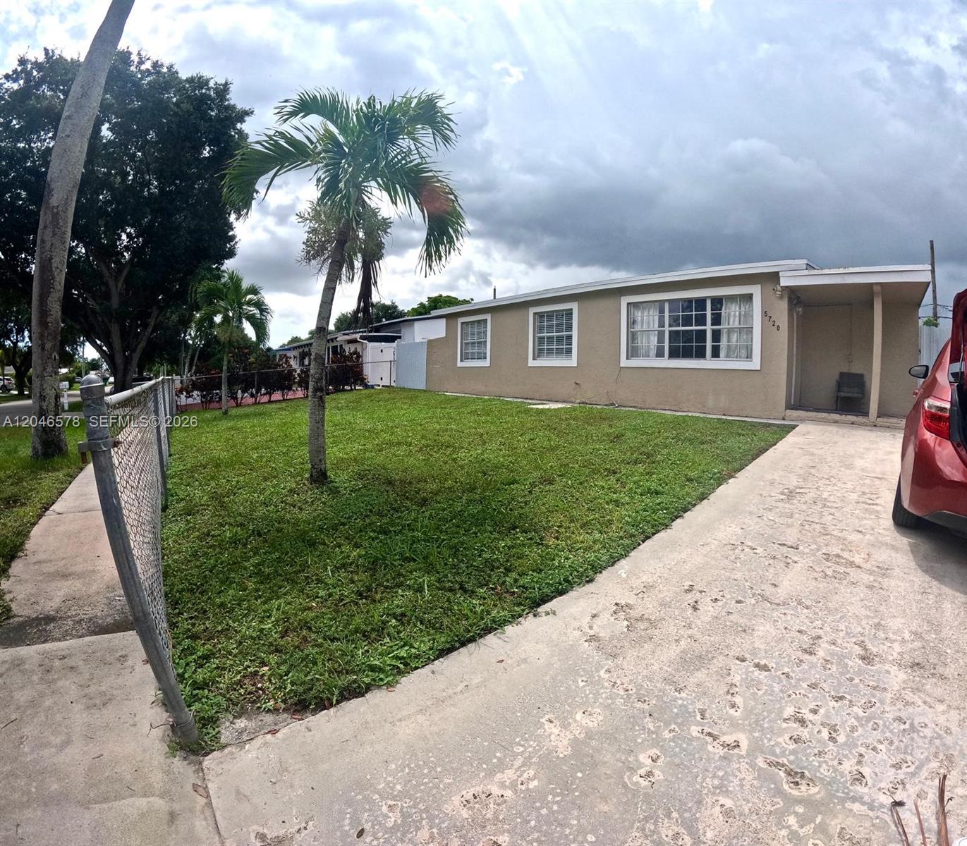 A single-story house with a tan exterior, a concrete driveway, and a front lawn — 5720 SW 38th Ct # 5720, Davie FL 33314, DAVIE, FL