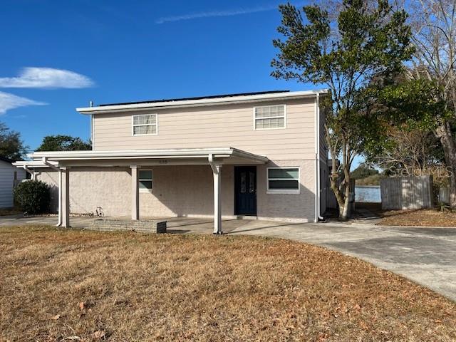 A two-story house with light siding, a covered porch, and a paved driveway — 635 LAKE HOLLOWAY BOULEVARD, LAKELAND, FL