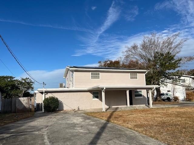 A two-story house with light-colored siding and a covered front porch sits on a lot — 635 LAKE HOLLOWAY BOULEVARD, LAKELAND, FL