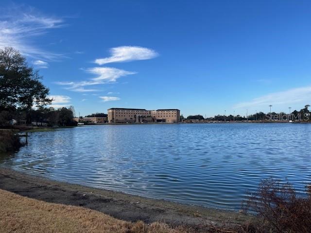 A large lake sits in the foreground with a multi-story building visible in the distance — 635 LAKE HOLLOWAY BOULEVARD, LAKELAND, FL
