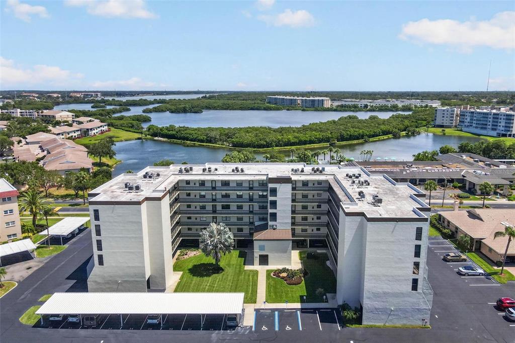 An aerial view of a multi-story apartment building with a central courtyard and parking lot — 9860 62ND TERRACE N UNIT 1043, ST PETERSBURG, FL