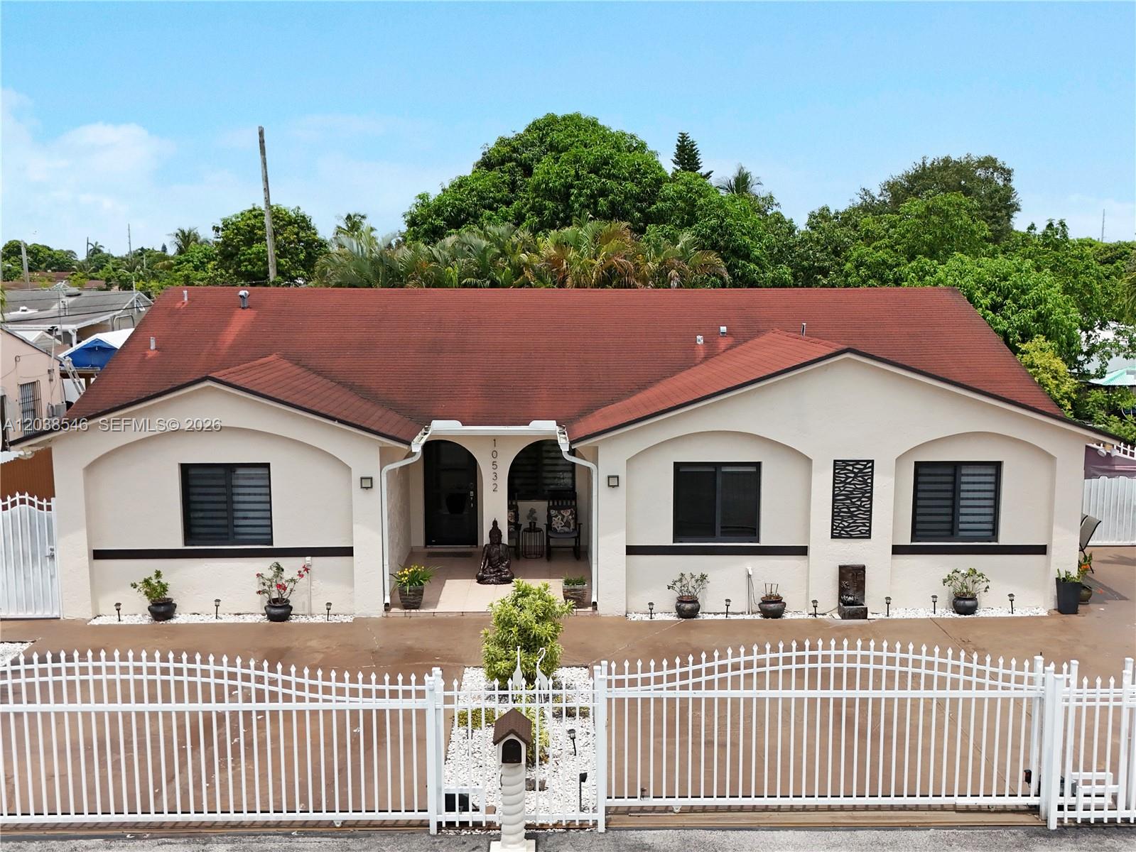 A single-story house with a red roof, cream stucco walls, and a white metal fence — 10532 NW 30th Ave., Miami FL 33147, MIAMI, FL