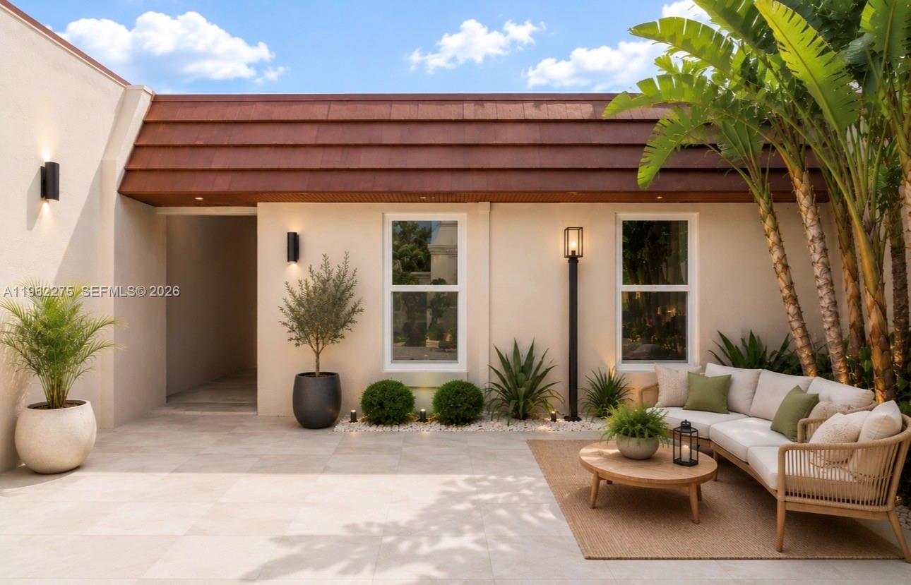 An outdoor patio features a beige sofa, a round coffee table, and potted plants — 7412 Big Cypress Dr, Miami Lakes FL 33014, MIAMI LAKES, FL