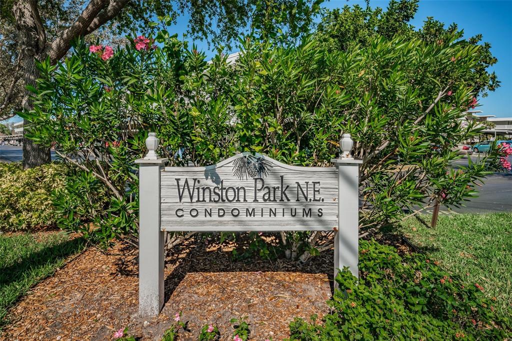 A sign for Winston Park N.E. Condominiums stands in front of a large green bush — 4915 BAY STREET NE UNIT 126, ST PETERSBURG, FL