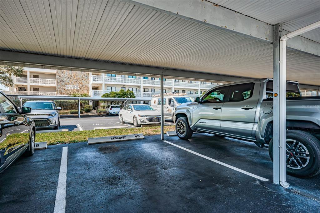 A covered parking space with a silver pickup truck parked in a residential lot — 4915 BAY STREET NE UNIT 126, ST PETERSBURG, FL