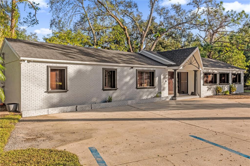 A single-story white brick building with a large concrete parking lot in front — 806 E 25TH STREET, SANFORD, FL