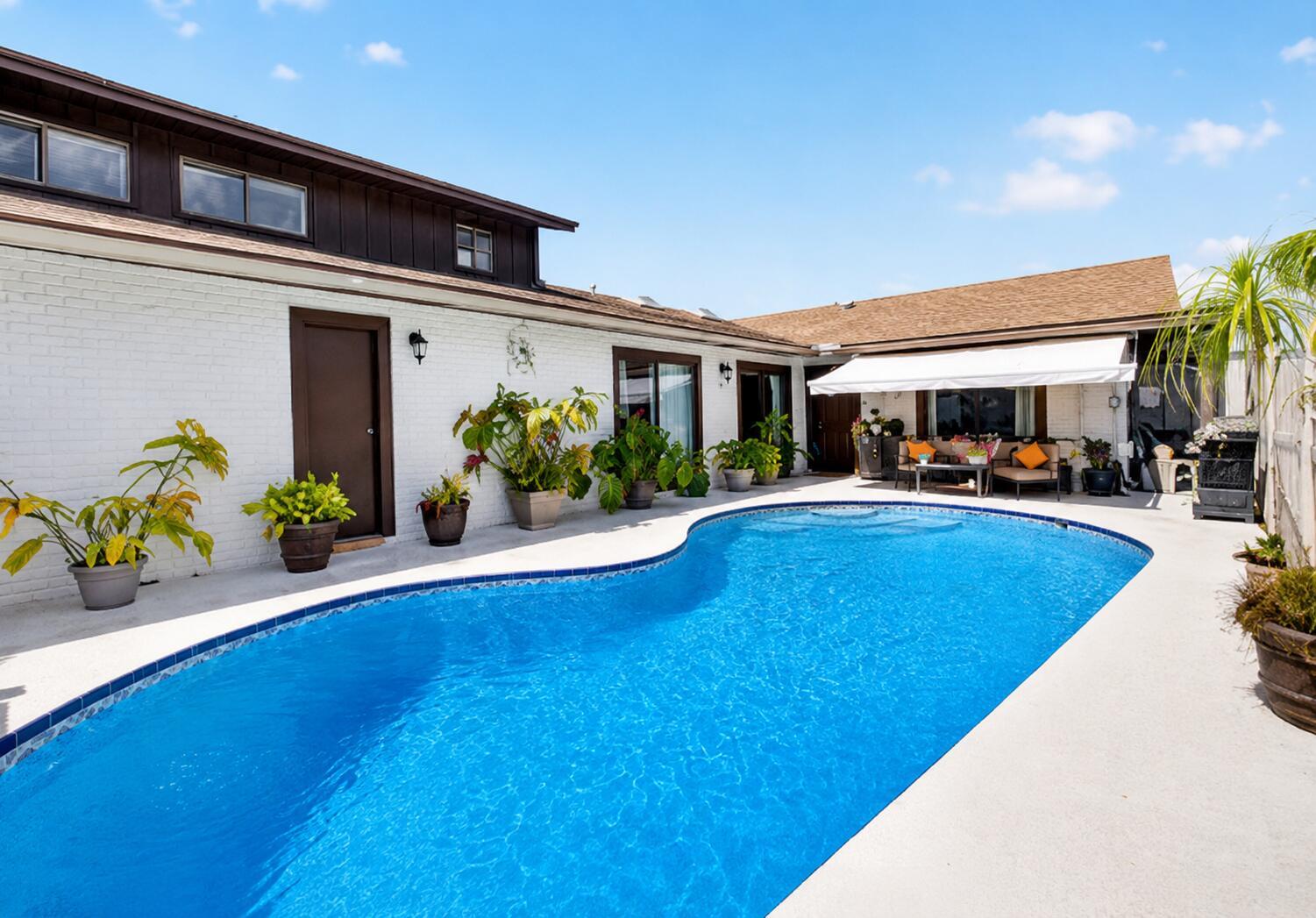 A kitchen with white cabinets, stainless steel appliances, black countertops, and a mosaic tile backsplash — 9622 Boca Gardens Parkway # B, Boca Raton FL 33496, BOCA RATON, FL