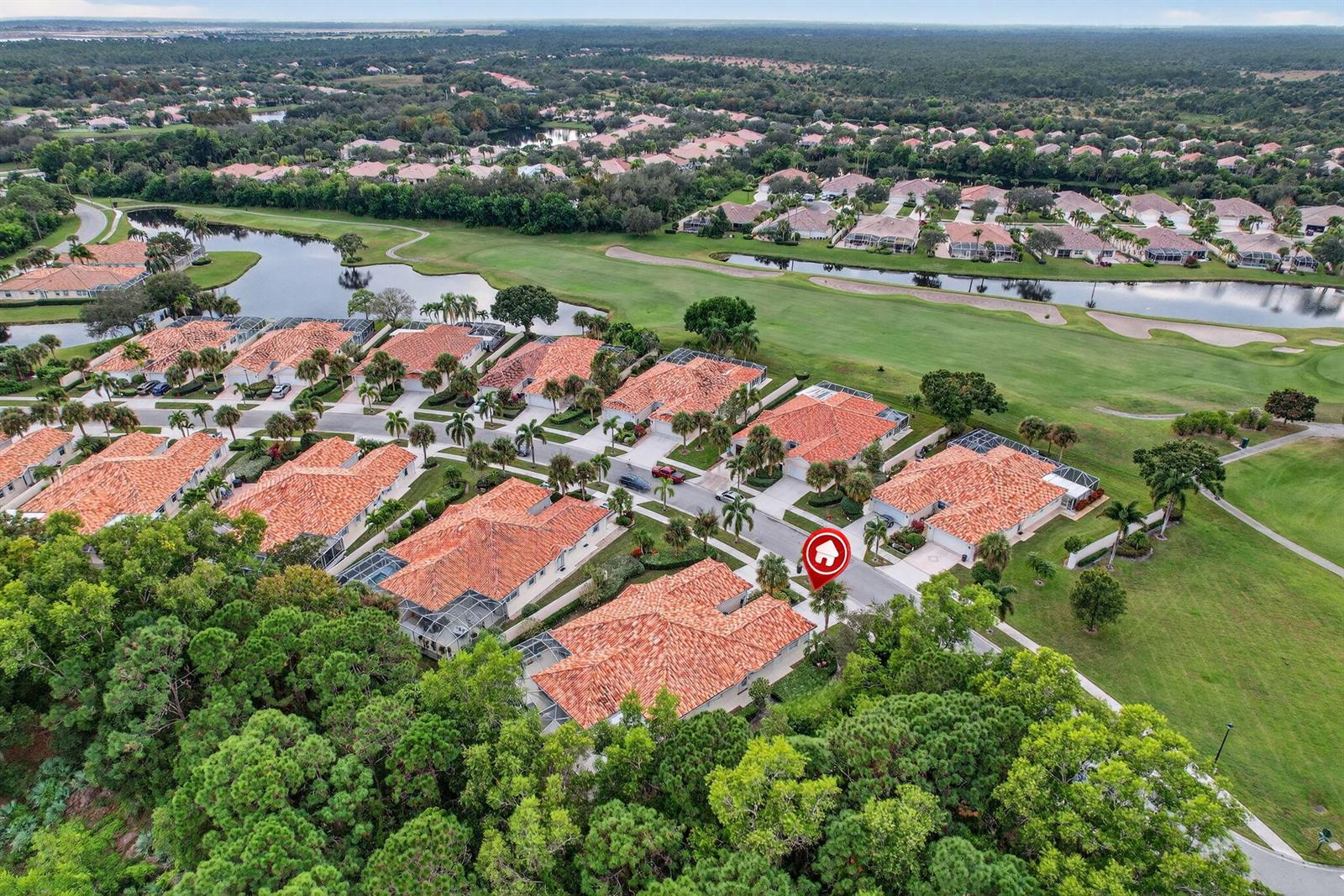 An aerial view shows a residential neighborhood with tile-roofed houses bordering a golf course — 8381 SE Double Tree Drive, Hobe Sound FL 33455, HOBE SOUND, FL