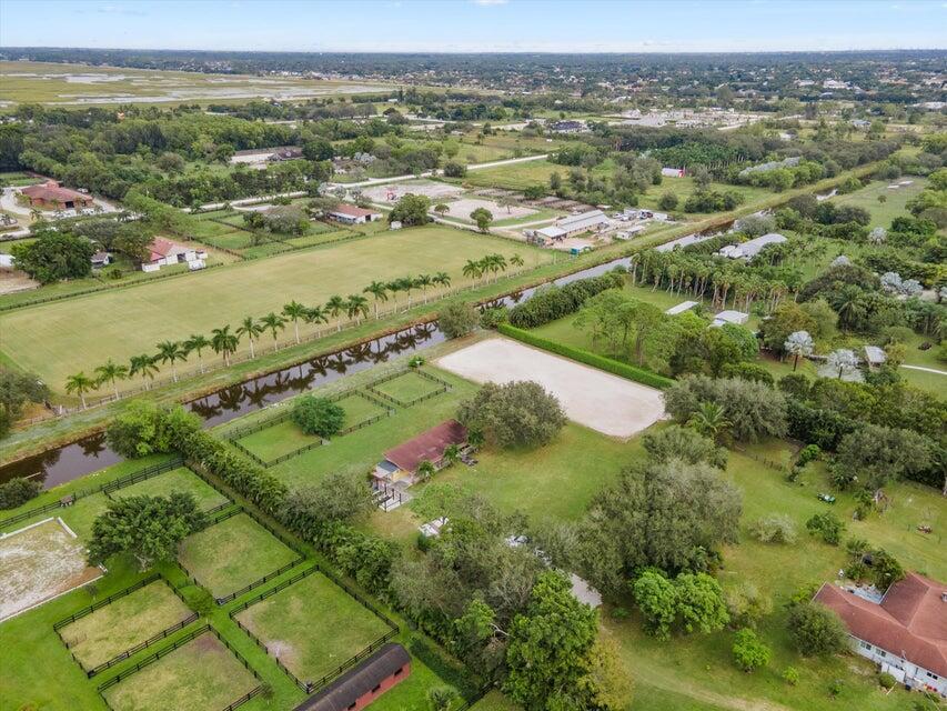 An aerial view shows a rural property with horse paddocks, a riding arena, and buildings — 16693 Deer Path Lane, Wellington FL 33470, WELLINGTON, FL