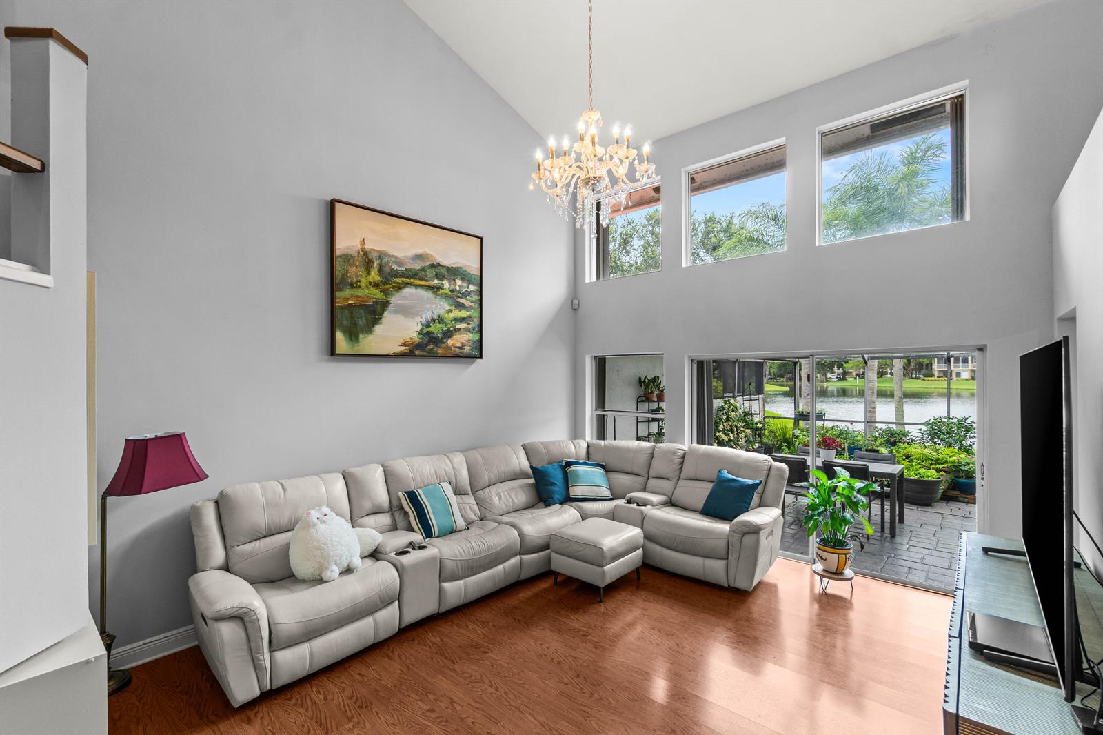 A living room with a vaulted ceiling, chandelier, sectional sofa, and sliding doors to a patio — 2011 NW 53rd Street, Boca Raton FL 33496, BOCA RATON, FL