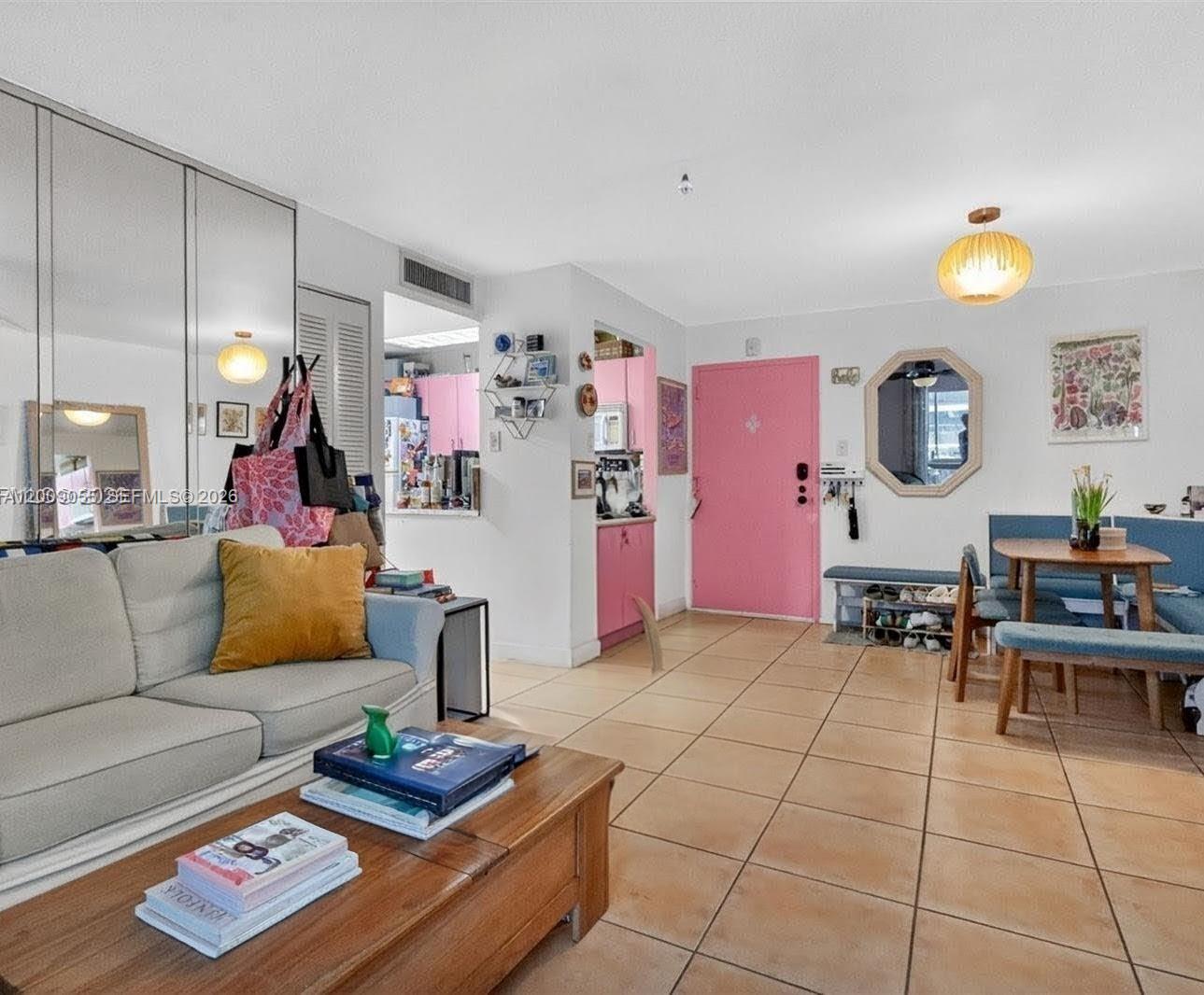 A living room with tile floors, a pink door, and a dining area with blue benches — 3304 Virginia St # 3D, Miami FL 33133, MIAMI, FL