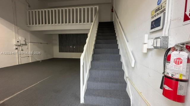 An interior view of a commercial space featuring a carpeted staircase leading to a loft — 12153 SW 131st Ave, Miami FL 33186, MIAMI, FL