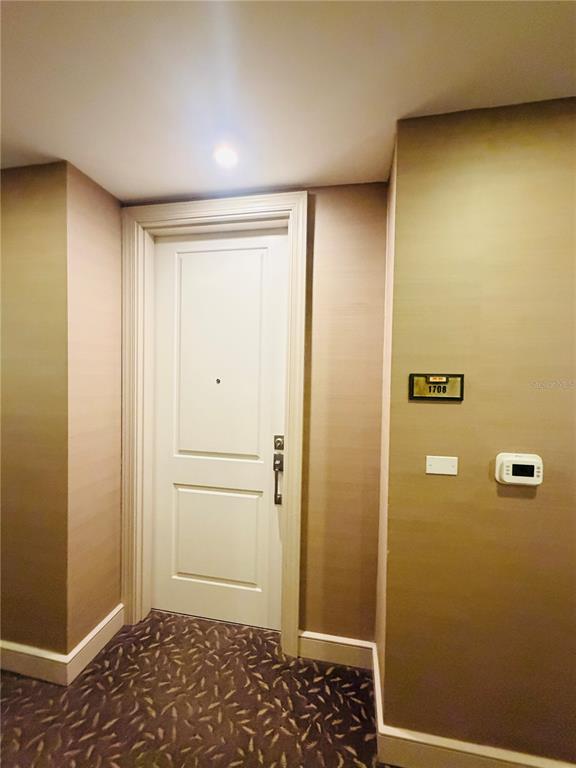 A white door with a peephole and electronic lock is set in a hallway wall — 2305 EDGEWATER DRIVE UNIT 1708, ORLANDO, FL