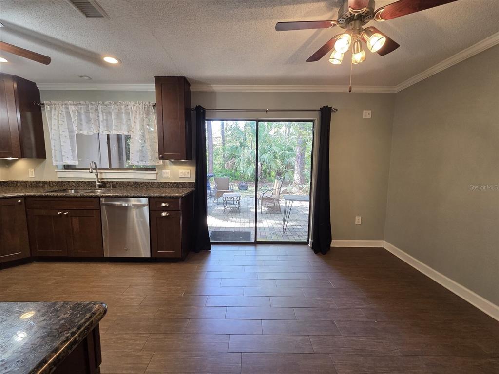 A bathroom features a dark wood vanity with a granite countertop and a tall cabinet — 2478 FOREST WAY, GAINESVILLE, FL