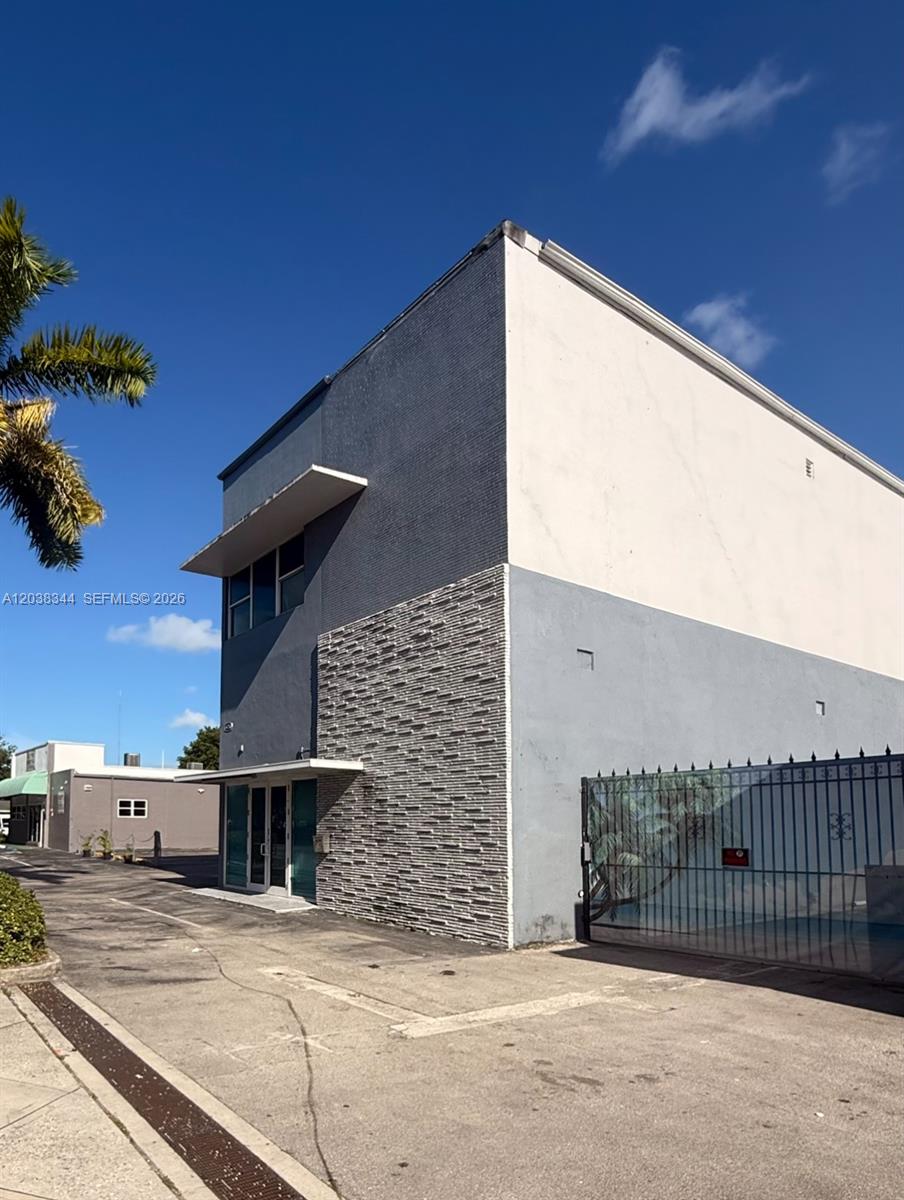 A two-story commercial building features a gray facade, stone-textured siding, and a gated parking area — 6236 Miramar Pkwy, Miramar FL 33023, MIRAMAR, FL