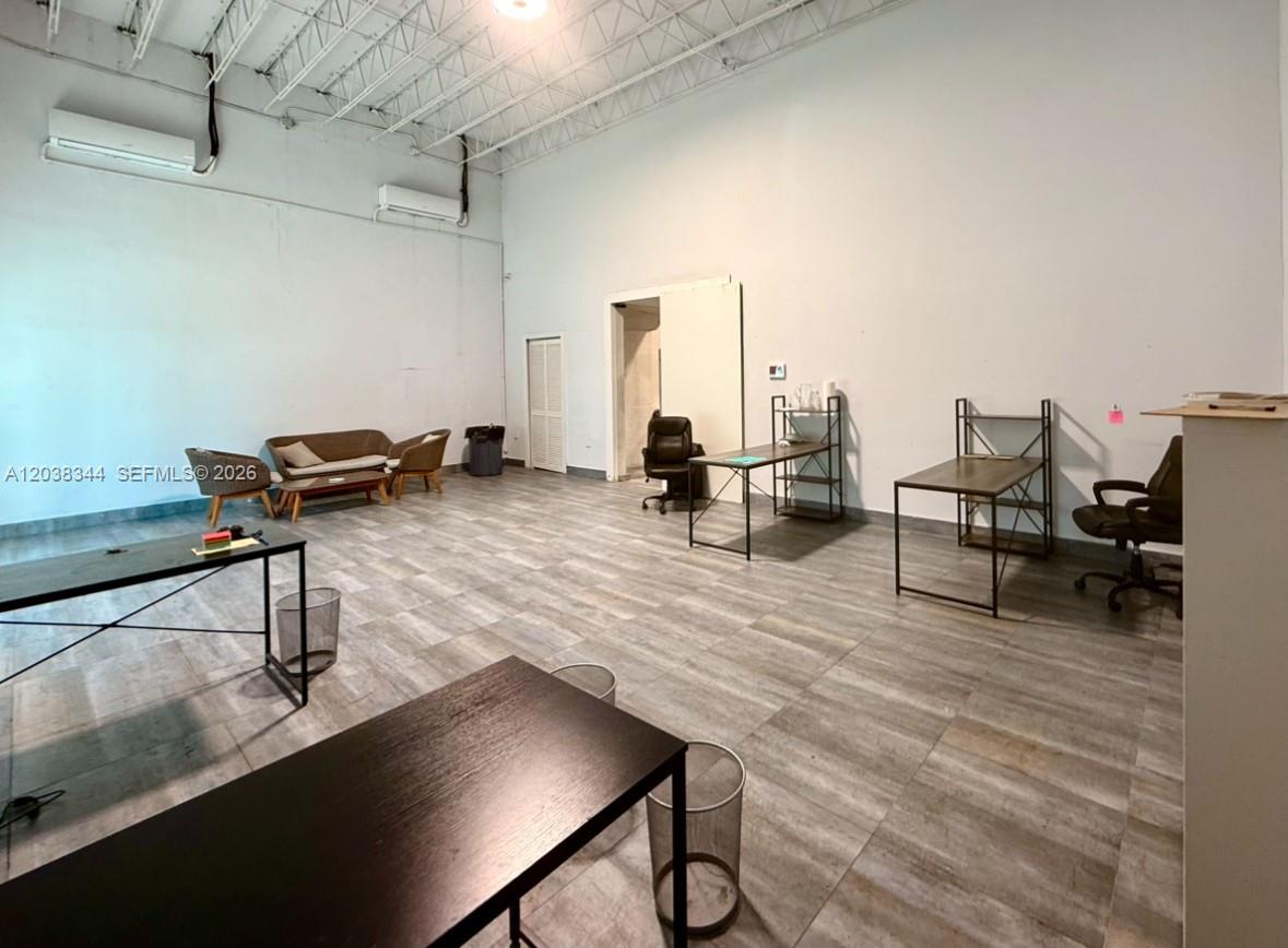 This office space features high ceilings, wood-look tile flooring, and several desks and chairs — 6236 Miramar Pkwy, Miramar FL 33023, MIRAMAR, FL