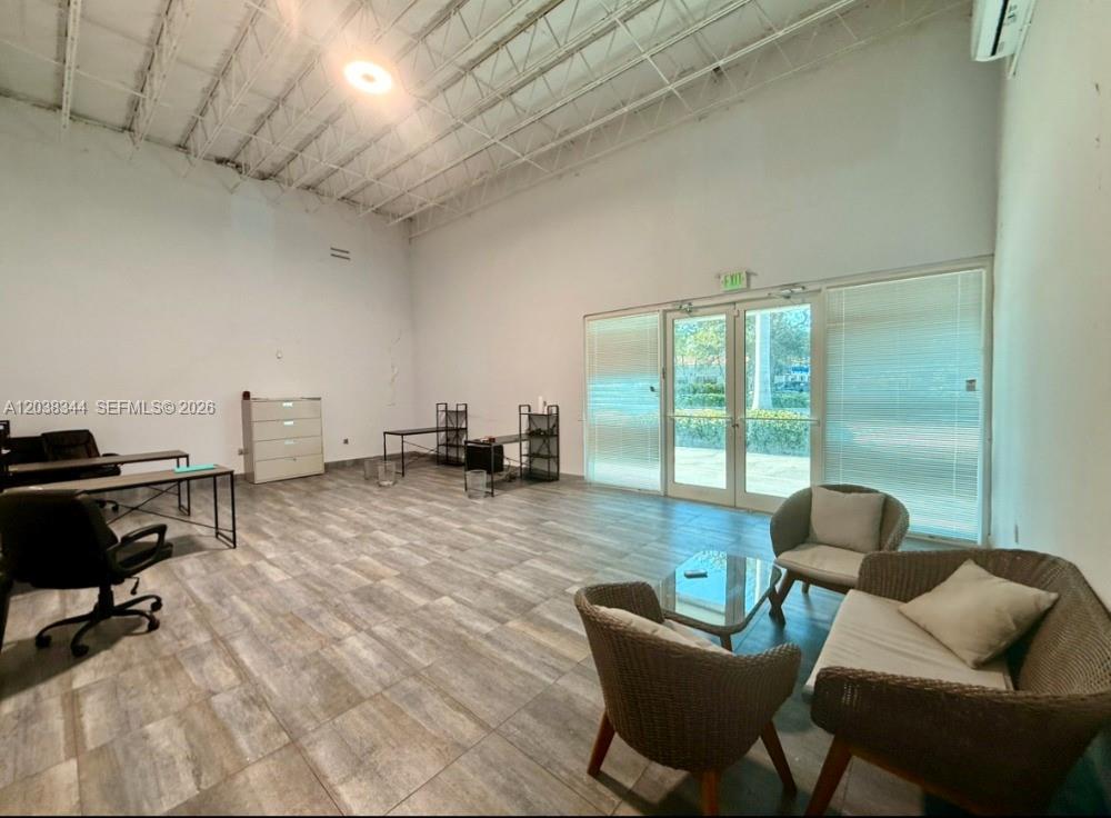 A spacious office room features high ceilings, tile flooring, and a glass door entrance — 6236 Miramar Pkwy, Miramar FL 33023, MIRAMAR, FL