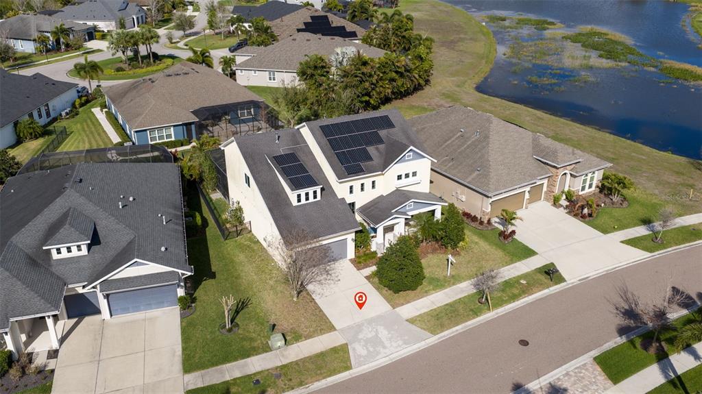 An aerial view shows a two-story suburban house with solar panels on the roof — 6313 HAVENSPORT DRIVE, APOLLO BEACH, FL