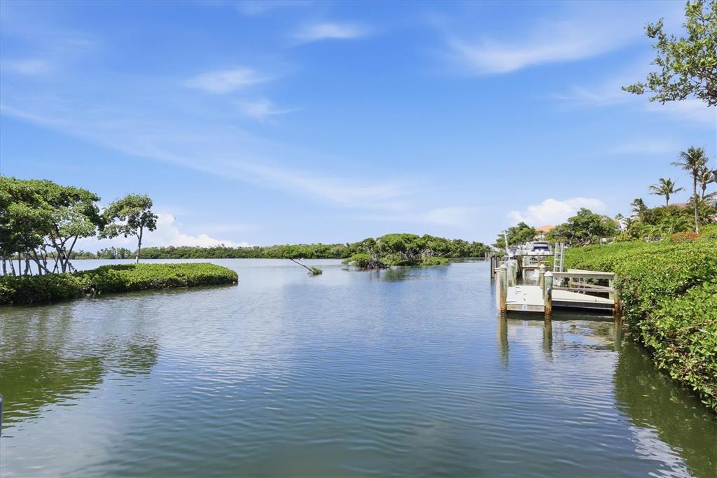 A wooden boat dock extends into a calm waterway surrounded by lush green mangroves — 3606 FAIR OAKS PLACE, LONGBOAT KEY, FL