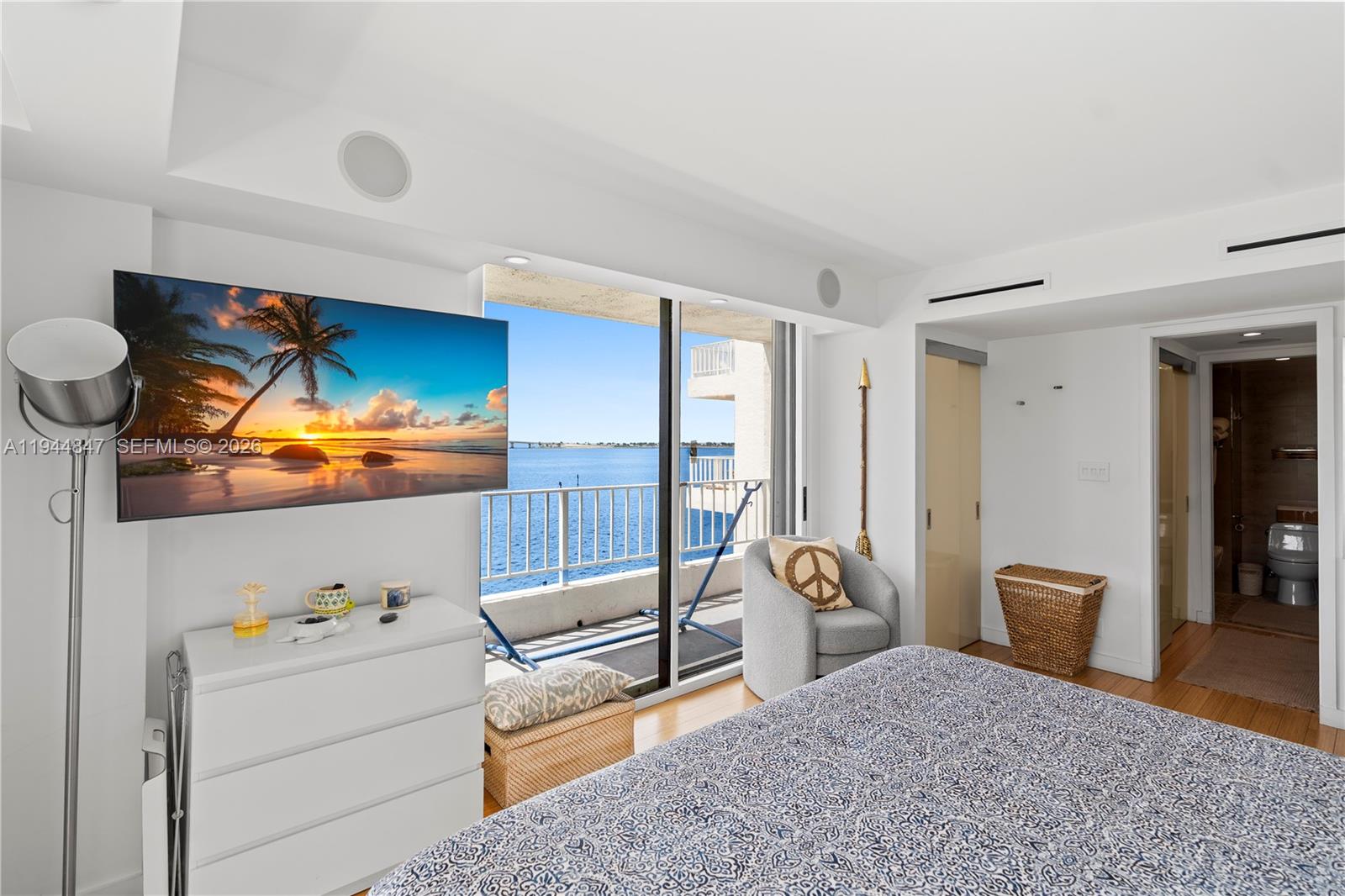 A bedroom features a wall-mounted television, a balcony with water views, and an attached bathroom — 200 SE 15th Rd # 5D, Miami FL 33129, MIAMI, FL