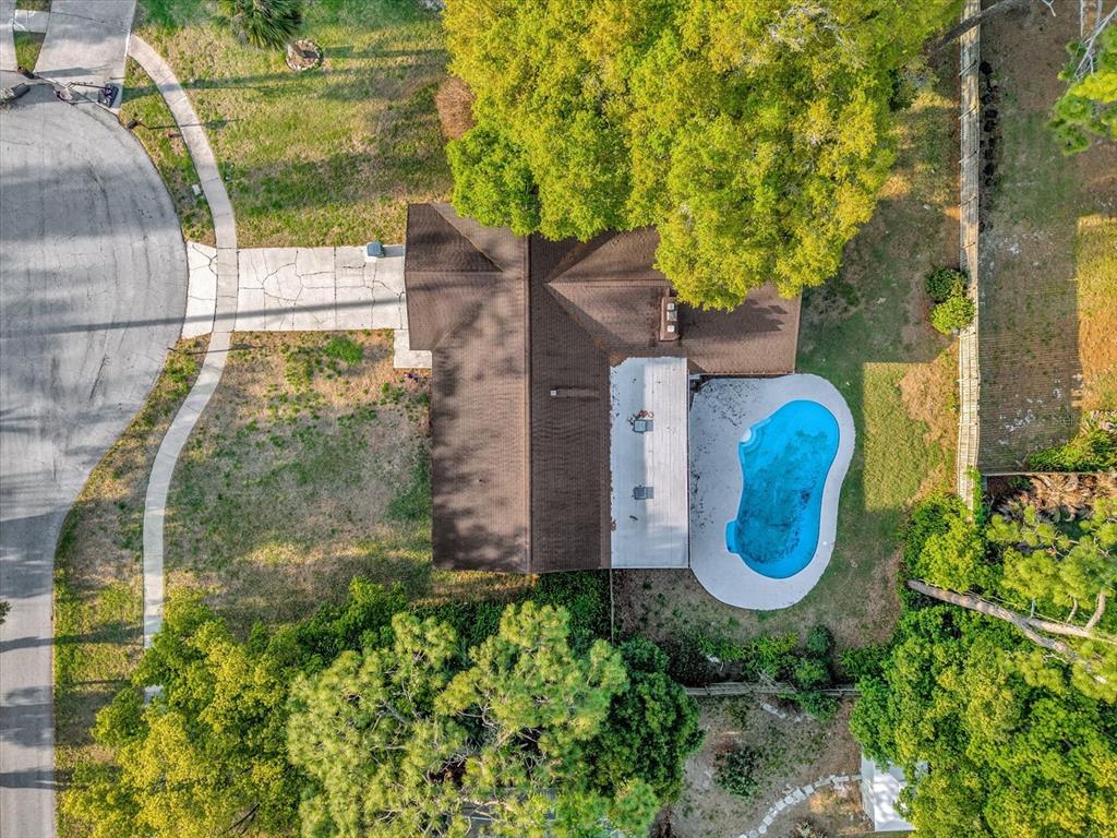 An aerial view shows a house with a brown roof, a pool, and a driveway — 2 HUDSON COVE, LONGWOOD, FL