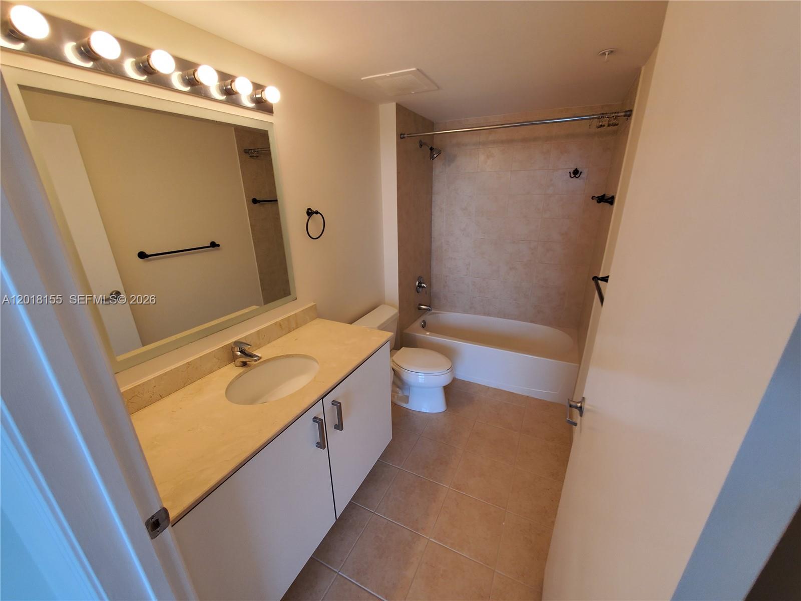 A bathroom features a vanity with a beige countertop, a toilet, and a tiled tub — 9066 SW 73rd Ct # 1808, Miami FL 33156, MIAMI, FL