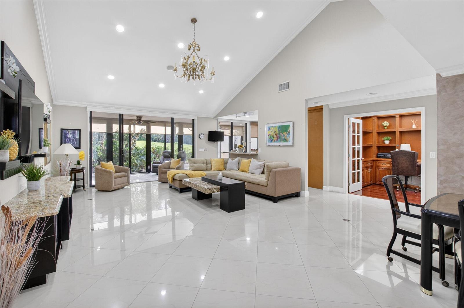 A spacious living room features high vaulted ceilings, white tile floors, and a large sectional — 19950 Sawgrass Lane # 5203, Boca Raton FL 33434, BOCA RATON, FL