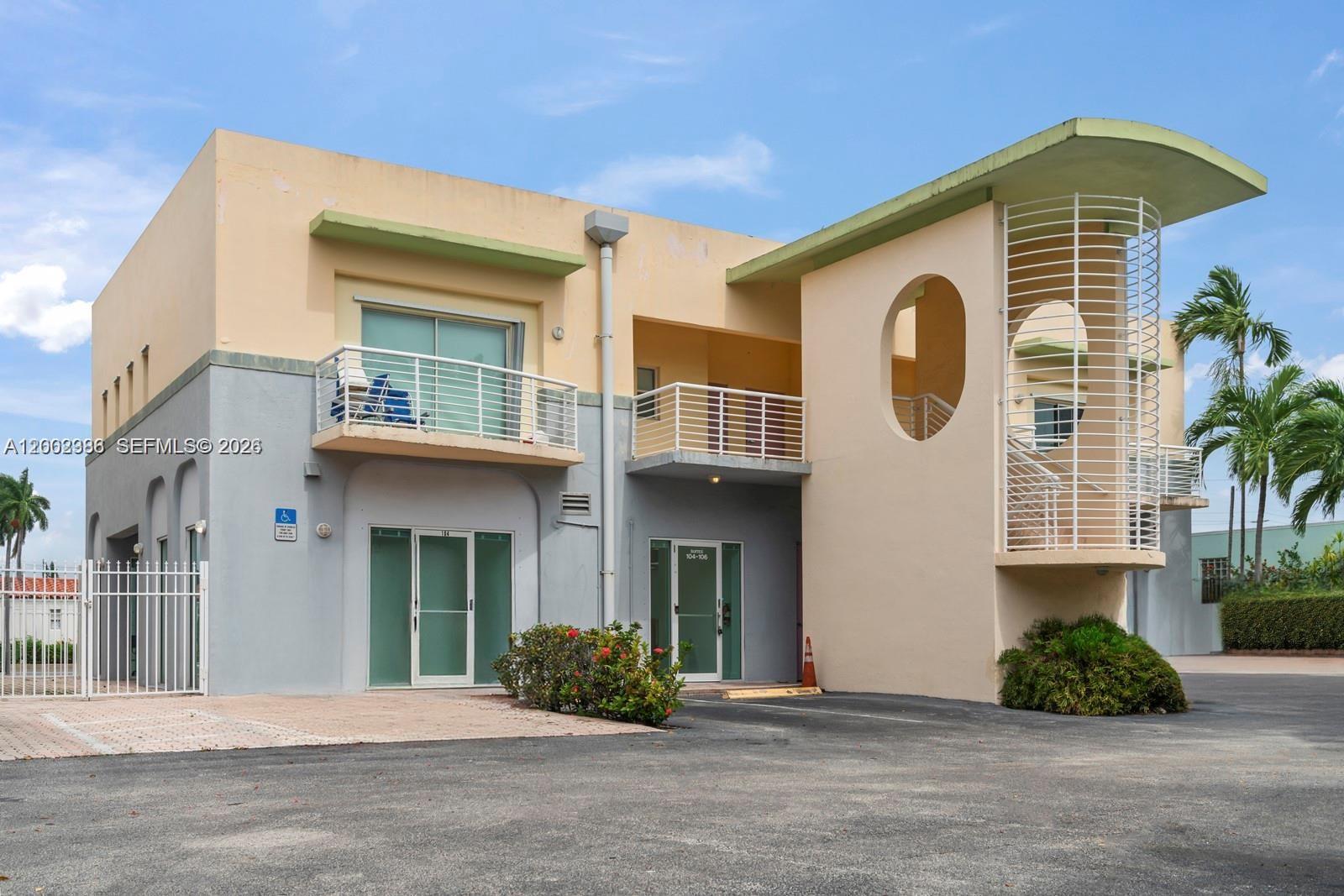 A two-story commercial building features a beige and gray exterior with balconies and staircases — 200 E Dania Beach Blvd, Dania Beach FL 33004, DANIA BEACH, FL