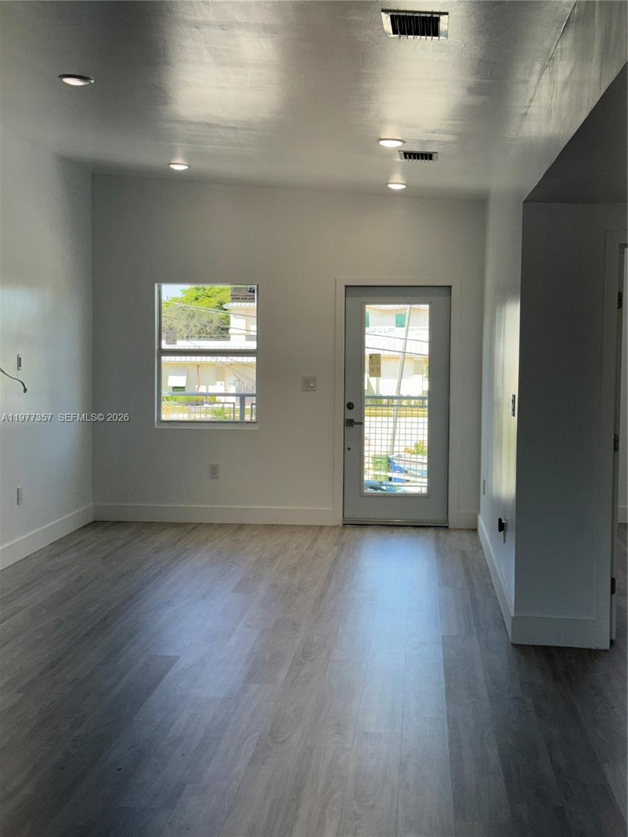 A room with light wood-look flooring, white walls, recessed lighting, a window, and a door — 526 NW 6th # A, Hallandale Beach FL 33009, HALLANDALE BEACH, FL
