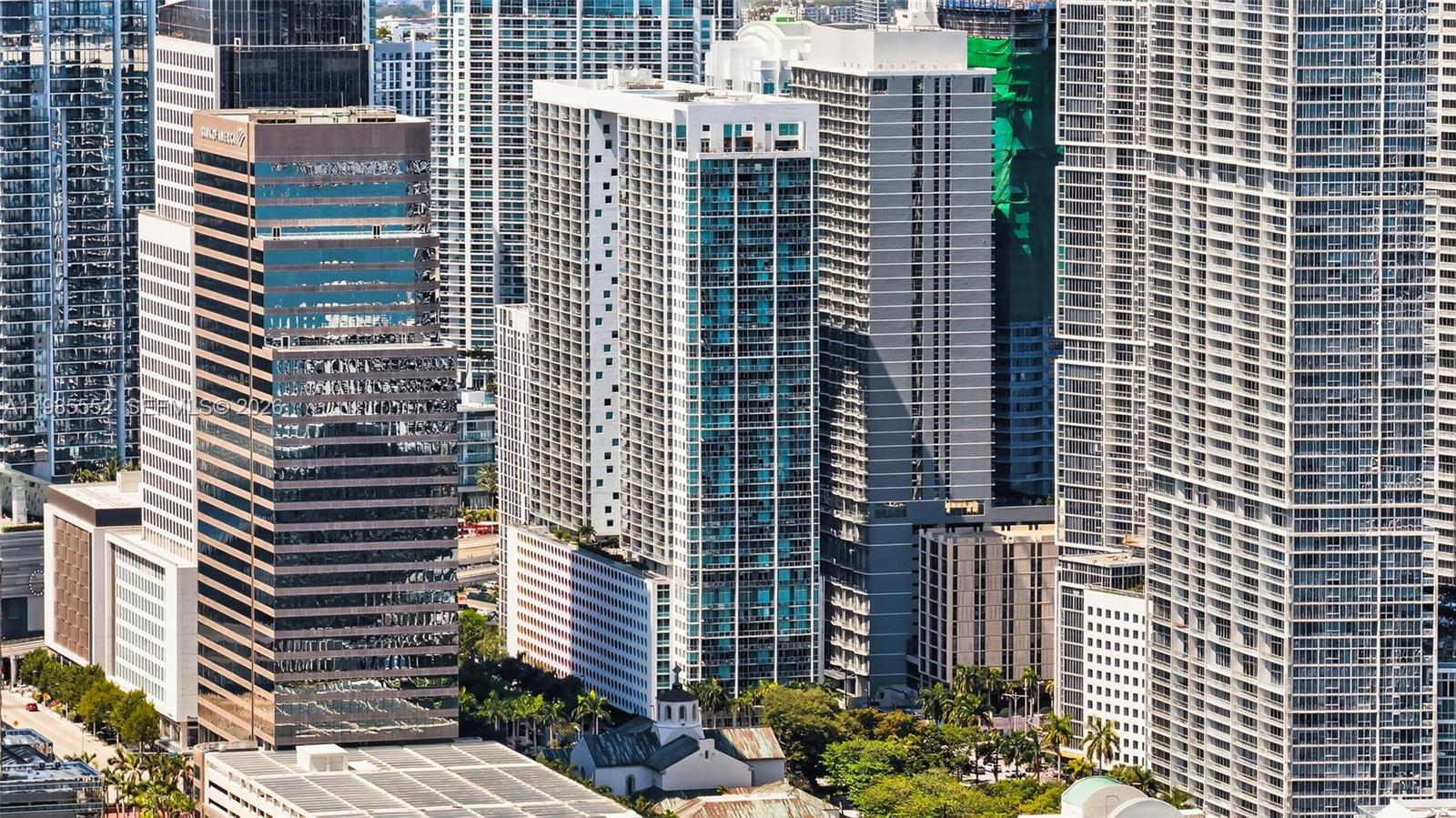 An aerial view of a dense urban skyline featuring several high-rise glass and concrete buildings — 500 Brickell Ave # 3901, Miami FL 33131, MIAMI, FL