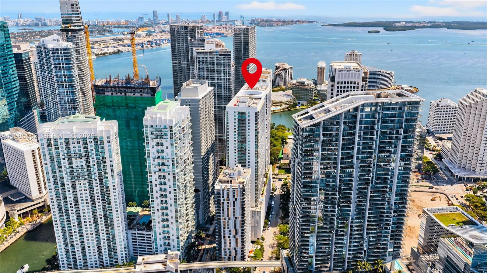 An aerial view shows a tall residential building marked with a red pin in Miami — 500 Brickell Ave # 3901, Miami FL 33131, MIAMI, FL