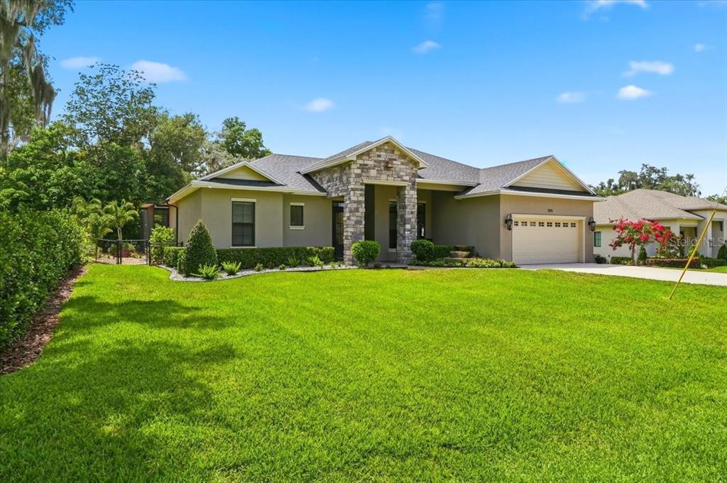 A single-story house with a stone facade, a two-car garage, and a large front lawn — 5111 DISMUKE DRIVE, LAKELAND, FL