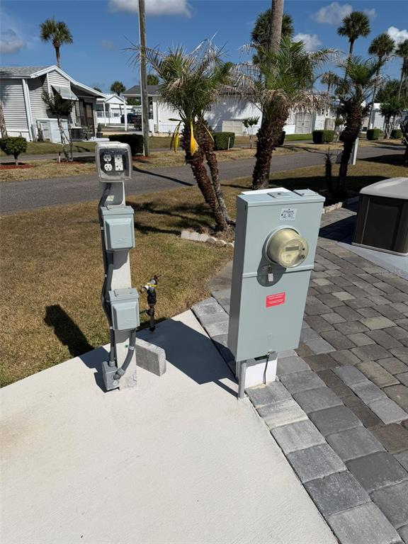An outdoor electrical pedestal and utility meter stand on a concrete pad near palm trees — 9000 US HWY 192 UNIT 833, CLERMONT, FL