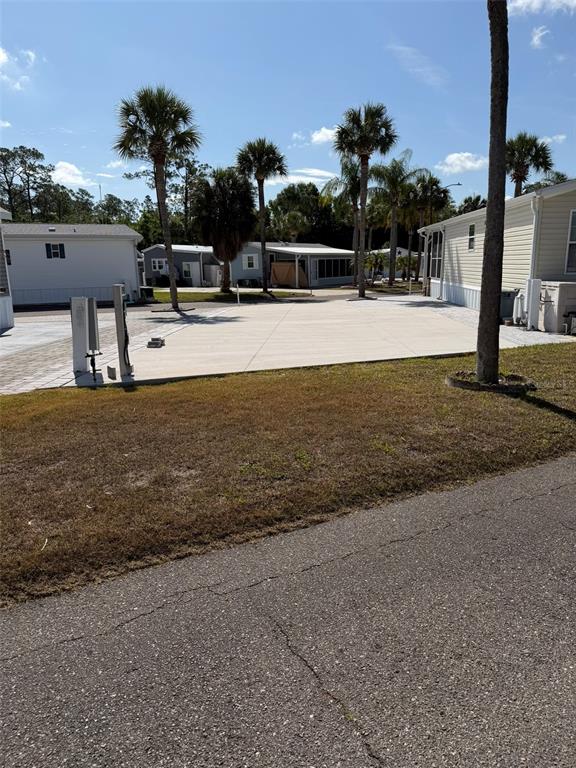 A paved lot sits between two manufactured homes in a residential community with palm trees — 9000 US HWY 192 UNIT 833, CLERMONT, FL