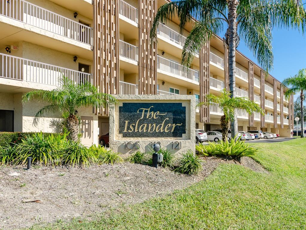 A multi-story apartment building with a prominent sign reading The Islander in the foreground — 105 ISLAND WAY UNIT 143, CLEARWATER, FL