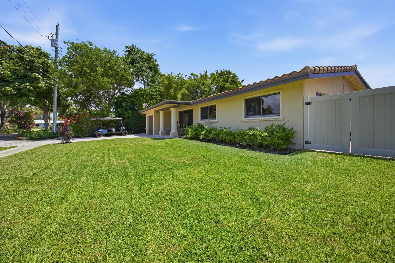 A single-story house with a tan exterior, tile roof, and a large front lawn — 730 SE 3rd Terrace, Pompano Beach FL 33060, POMPANO BEACH, FL