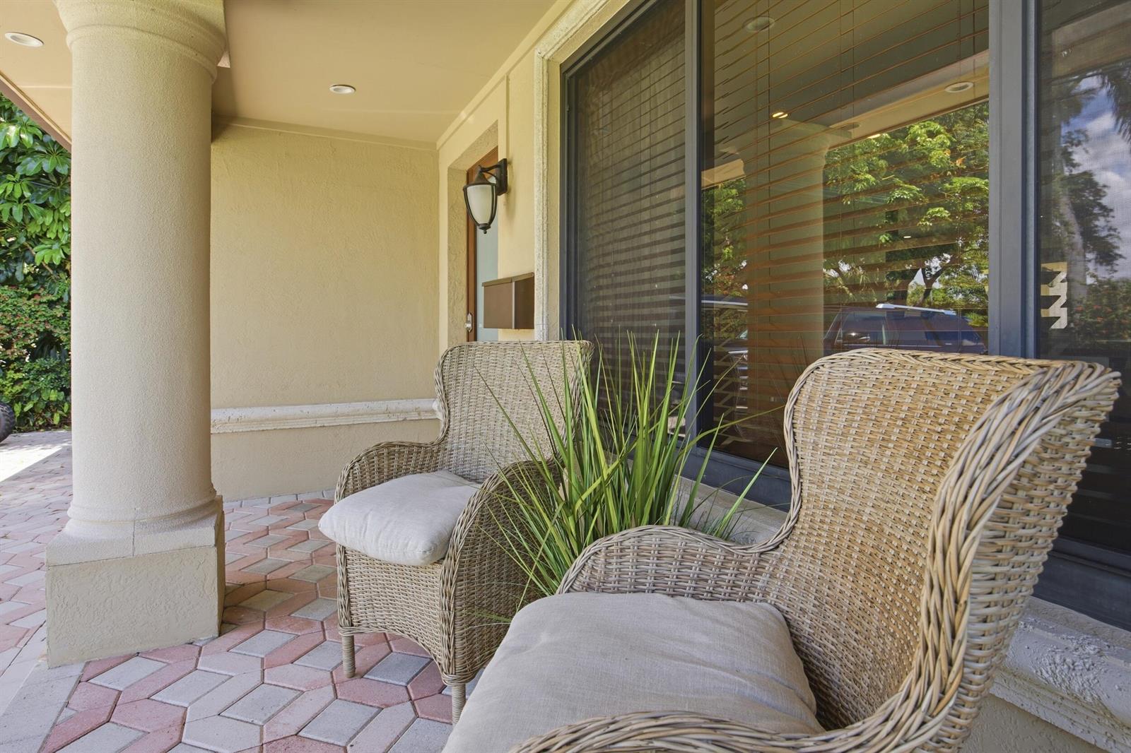 Two wicker chairs sit on a paved patio next to a large window and column — 730 SE 3rd Terrace, Pompano Beach FL 33060, POMPANO BEACH, FL