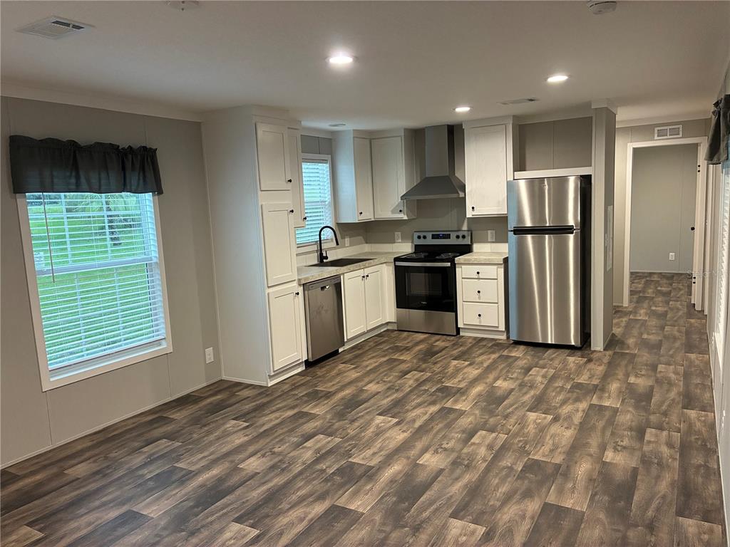 A kitchen with white cabinets, stainless steel appliances, and wood-look flooring — 263 EDGEWOOD BOULEVARD, LAKE WALES, FL