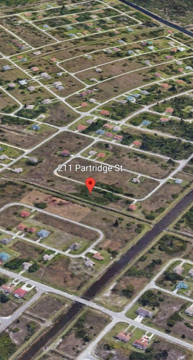 An aerial view of a vacant residential lot in a sparsely developed suburban neighborhood — 211 Partridge, Lehigh Acres FL 33974, LEHIGH ACRES, FL