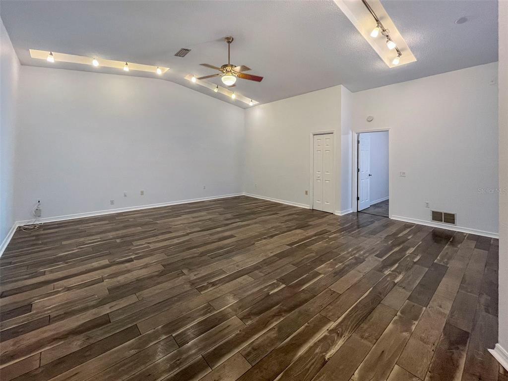 A spacious living room features vaulted ceilings, recessed lighting, a ceiling fan, and wood flooring — 3957 PROCTOR ROAD, SARASOTA, FL