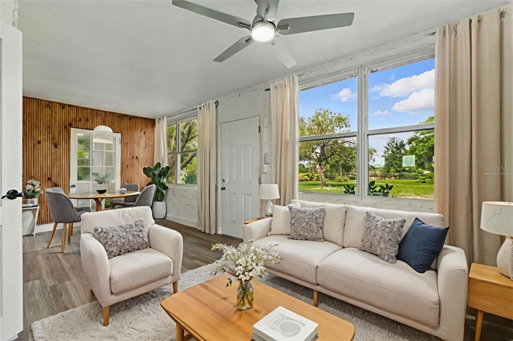 A living room features wood-paneled walls, a white sofa, an armchair, and large windows — 8812 OAKWOOD DRIVE, LAKE WALES, FL